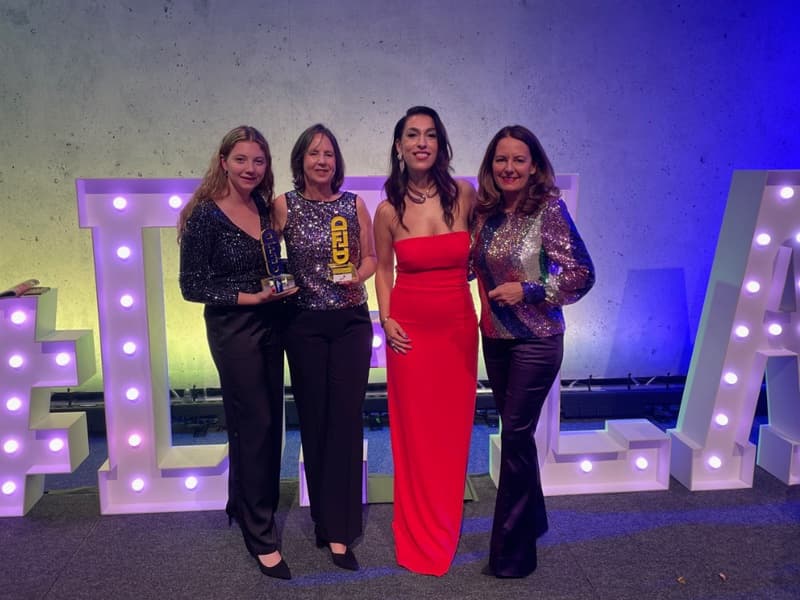 Vier Frauen stehen auf einer Bühne und halten einen Award in den Händen